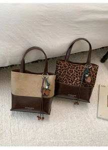Detail of vintage patchwork tote bags featuring suede and leopard print with woven charms