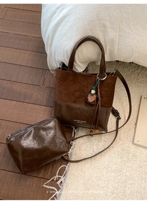 Detail view of a vintage dark brown tote bag with a small matching zipper pouch