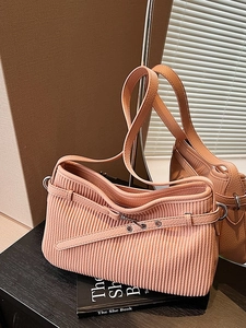 Pink pleated leather bucket bag with silver hardware on a book with mirror reflection