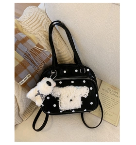 Detailed view of polka dot tote bag featuring white plush dog patch and fluffy charm