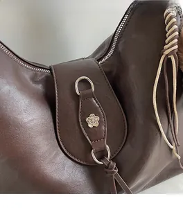 Detailed macro view of dark brown leather bag with silver camellia metal buckle decoration
