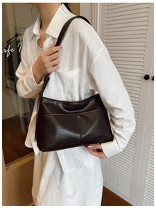 Detail showing high-quality polished dark brown leather with vertical stitching and branding