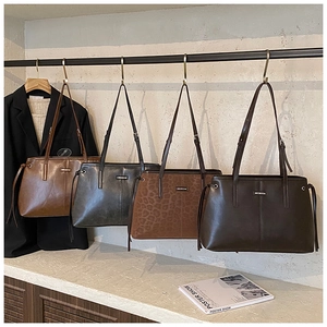 Detail showing four leather tote bags in brown, grey, leopard and dark coffee finishes