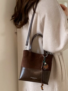 Vintage dark brown leather crossbody bucket bag with elegant tassel charm for women