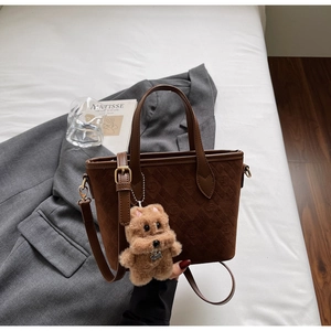 Detail of brown suede bucket bag with F-monogram embossing and plush dog charm