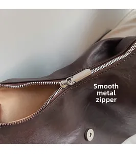 Macro shot of smooth silver metal zipper and brown leather texture on handbag