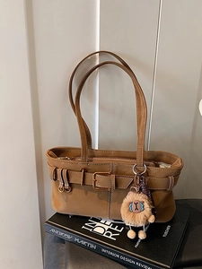 Vintage brown suede bucket bag with decorative buckle strap and plush lion charm