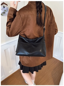 Chic black matte leather tote bag styled with a brown suede jacket for fall fashion look