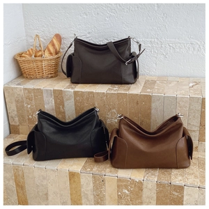 Détails de trois sacs cabas minimalistes en cuir de couleurs noir, marron foncé et caramel