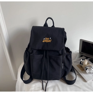 Detail of black backpack with YOU JI BEAR embroidery and adjustable drawstring closure