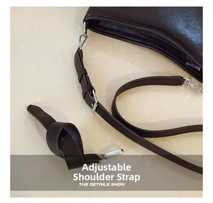 Détail de la bandoulière réglable en cuir noir avec boucle argentée du cabas