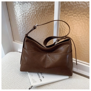 Detailed close-up of dark brown tote bag showing smooth faux wax leather and adjustable strap
