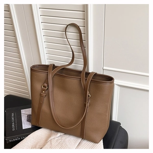 Detail of coffee brown pebble leather tote bag with gold hardware and shoulder strap