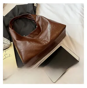 Detail view of glossy brown oversized hobo shoulder bag with a vintage pleated PU texture