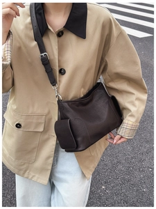 Détail d'un sac à bandoulière rétro marron foncé avec texture cuir et sangle réglable