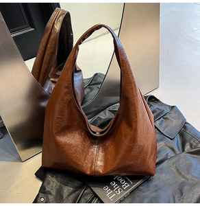 Detail of vintage brown leather hobo bag with glossy wrinkled texture and chic design