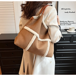 Close-up of brown suede tote bag with white faux fur trim and premium leather handle