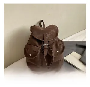 Detail view of vintage brown leather backpack with buckle straps and front pockets