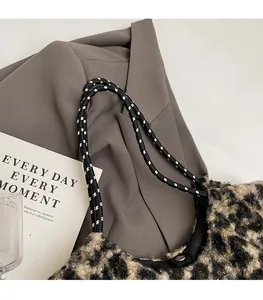 Close-up of leopard print tote bag featuring black and white woven rope shoulder straps