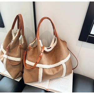 Close-up of brown matte tote bag with white fleece trim and adjustable shoulder strap