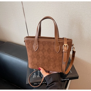 Detail of dark brown tote bag with quilted suede texture and adjustable shoulder strap