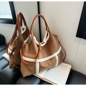 Detail of a brown suede tote bag featuring plush white faux fur trim and adjustable strap