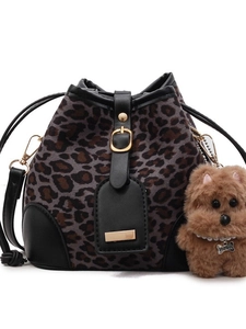 Gray leopard print bucket bag with black trim and plush puppy charm on white background