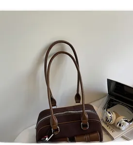 Sac Boston vintage marron avec poignées présenté dans un décor de bureau à domicile