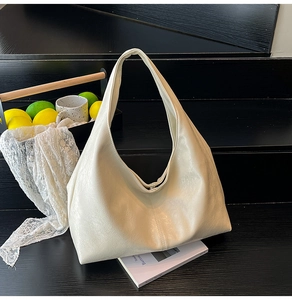 Close-up of creamy white faux leather tote bag showing soft texture and metal magnetic snap
