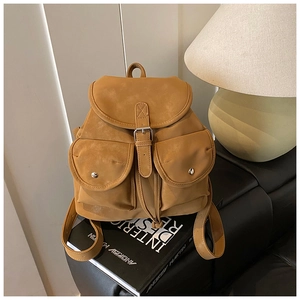 Close-up of ginger vintage backpack with dual front pockets and silver buckle closure