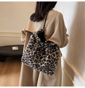 Detail view of large leopard print plush tote bag with woven shoulder strap on model