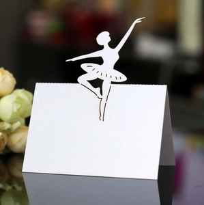 Macro detail of laser-cut ballerina wedding place card in shimmering pearlescent white paper
