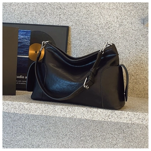 Détail du sac cabas en cuir noir avec ferrures argentées et bandoulière réglable chic