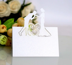 Macro shot of laser-cut Mr & Mrs wedding place cards with elegant pearl finish paper
