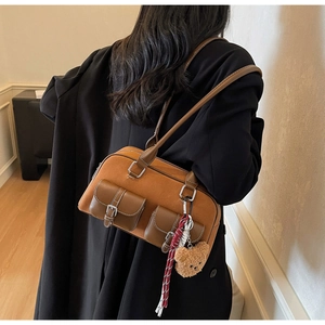 Détail du sac à bandoulière rétro avec doubles poches avant et breloque ours peluche