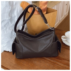 Détail du sac cabas en cuir marron avec sangle ajustable et boucle métallique