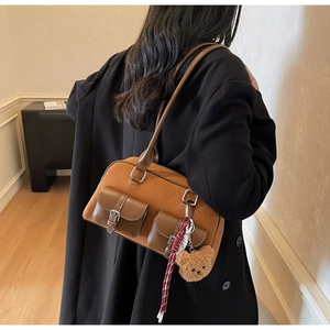 Détail du sac cabas en daim caramel avec doubles poches et breloque ours en peluche
