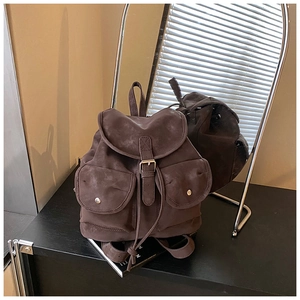 Detail view of large brown vintage backpack with leather buckles and drawstring closure