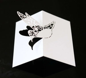 Elegant white laser-cut 3D bird place card with intricate hollowed patterns for weddings
