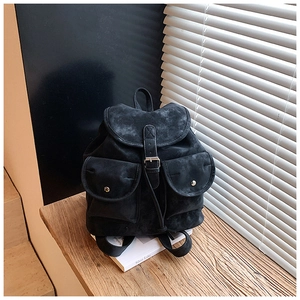 Close-up of black matte faux suede backpack with drawstring closure and buckle flap