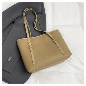 Detail of camel brown lychee leather tote bag with gold hardware and adjustable strap