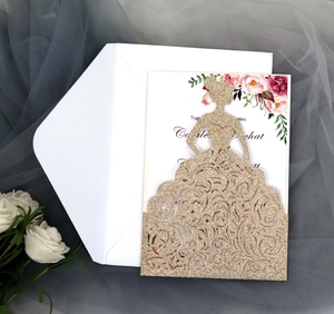 Close-up of laser cut glitter gold bridal gown wedding invitation card and white envelope