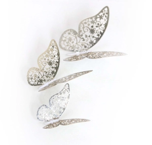 Detail of 3D silver butterflies with laser-cut floral patterns and metallic texture