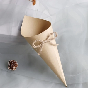 Detail of kraft paper confetti cone with rustic twine bow for wedding petal toss