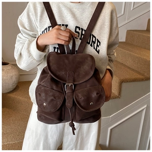 Detail of dark brown vintage backpack with retro buckle closure and matte leather texture