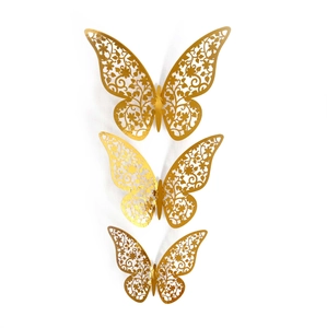 Detailed macro view of laser-cut gold butterfly wall decals with floral vine patterns