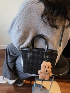 Chic black diamond lattice handbag with a cute brown puppy plush charm for women