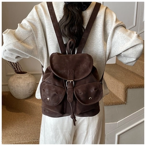 Detail of dark brown faux suede backpack with magnetic buckles and vintage buckle closure