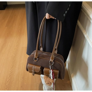 Détail du sac bandoulière en daim marron avec poches à boucle et charm ours en peluche