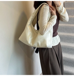 Close-up of minimalist cream hobo bag showing supple leather texture and large capacity